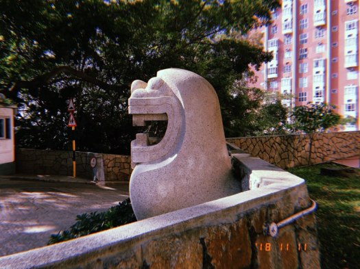 Cute smiling stone lion sculpture by Rodolfo Nolli at HKU's High West